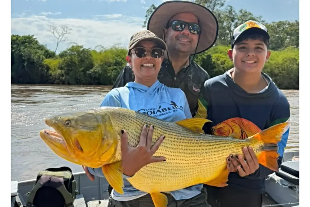 Mayara com sua "barra de ouro" ao lado da família após fisgar o peixe. (Foto: Anna Júlia Azambuja)