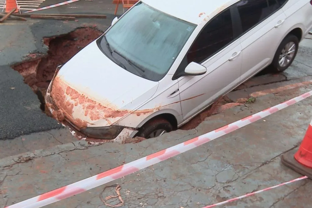 Carro dentro da cratera aberta durante temporal (Foto: Eduardo de Almeida)